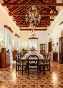 uma sala de jantar com mesa, cadeiras e um lustre em amã Stays & Trails, Cardozo House em Candolim