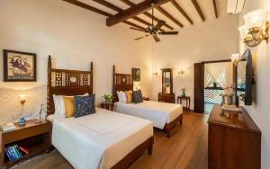 um quarto com duas camas e um ventilador de teto em amã Stays & Trails, Cardozo House em Candolim mais 2 fotografias