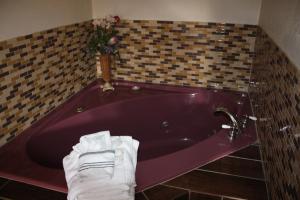 een paars bad met handdoeken in de badkamer bij Economy Inn - Statesville in Statesville