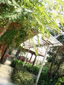 a wooden structure with a canopy in a garden at ต้งโฮมหละปูน in Lamphun