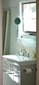 a white sink sitting under a window in a bathroom at Meredith House in Swansea