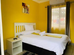 Duas camas num quarto com paredes amarelas em Sivande B&B em Richards Bay