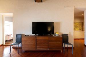 a living room with a tv and two chairs at Pantheon Palazzo Nari in Rome