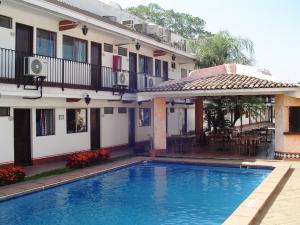 una piscina di fronte a un edificio di Hotel & Suites Coral a Puerto Vallarta