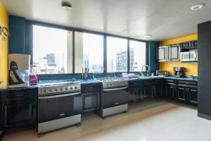 a large kitchen with black appliances and a large window at Caravansaro Penthouse Polanco in Mexico City
