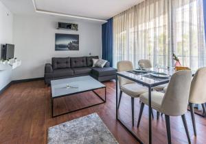 ein Wohnzimmer mit einem Sofa, einem Tisch und Stühlen in der Unterkunft Aspendos eXtra in Antalya