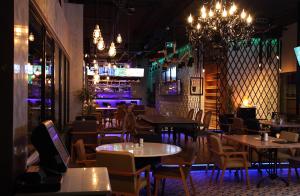 a restaurant with tables and chairs and a bar at Tuzla Town Hotel in Tuzla
