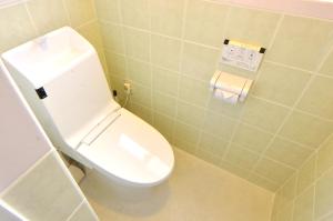 a bathroom with a white toilet in a room at Purple House in Chatan