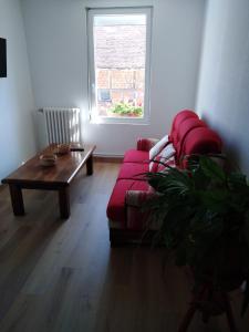 a living room with a red couch and a table at La Garitinne in Onjon