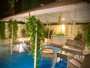 una piscina con mesas, sillas y plantas en Toffa Place In Rome en Roma