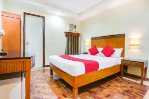 een slaapkamer met een groot bed met rode kussens bij Super OYO 406 Royale Parc Inn & Suites in Manilla