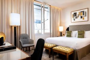 a hotel room with a bed and a desk and a chair at Le Tsuba Hotel in Paris