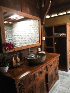 a bathroom with a bowl sink on a wooden counter at The Jungle Villa in Ubud