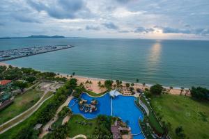 an aerial view of a resort with a pool and the ocean at Movenpick Residences Pattaya with Ocean View in Na Jomtien