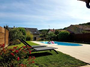 una piscina con chaise longue en un patio en Dépendance au goût de vacances, en Moulainville-la-Basse
