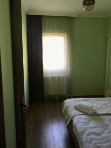 a small bedroom with a bed and a window at Riverside Kazbegi in Stepantsminda