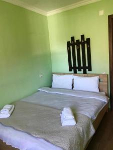 a green room with a bed with towels on it at Riverside Kazbegi in Stepantsminda