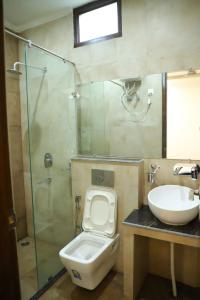 uma casa de banho com um WC, um lavatório e um chuveiro em Best Properties In Rishikesh em Rishikesh