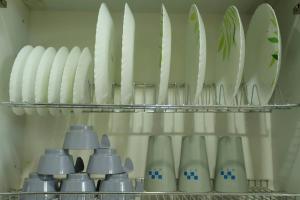 a shelf with a bunch of white bowls and plates at The Most Beautiful Property Of Rishikesh in Rishīkesh