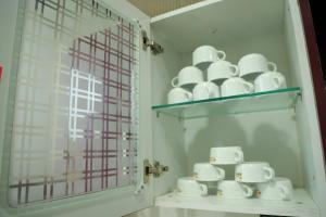 a shelf with a bunch of white cups on it at The Most Beautiful Property Of Rishikesh in Rishīkesh