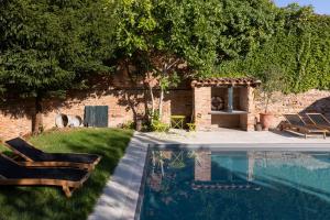 a swimming pool in a yard with two chairs and a fireplace at Numero22 Chambres d'hôtes in Montauban