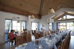 un grupo de personas sentadas en mesas en un restaurante en Hotel garni Milseburg, en Hilders