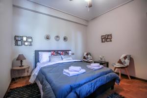 una camera da letto con un letto blu con asciugamani sopra di Only yours Meteora a Kalabaka
