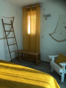 a bedroom with a bed and a ladder and a chair at Maxima Sunset in Sainte-Maxime