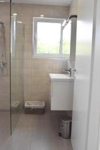 bagno con lavandino e finestra di Apartma med oljkami - Portorož a Portoroz