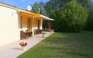 a house with chairs and flowers in a yard at Locatlantique in Aytré