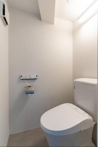 ein weißes Bad mit einem weißen WC in einem Zimmer in der Unterkunft Front Field瀬名波 in Yomitan