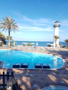 una piscina con un faro en el fondo en Casa d' amare, en Playa del Águila