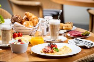 - une table avec des assiettes de nourriture et de boissons dans l'établissement THE MADISON Hotel Hamburg, à Hambourg