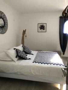 a white bed with pillows on it in a bedroom at Maxima Sunset in Sainte-Maxime