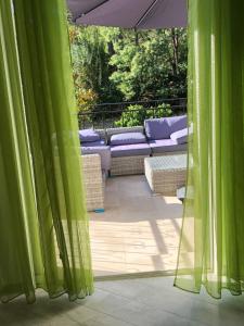 a view of a patio with green curtains at Maxima Sunset in Sainte-Maxime