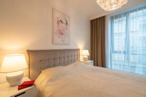 a bedroom with a bed with a chandelier and a window at Easyrooms Dzirnavu in Rīga