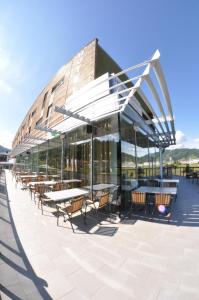 un bâtiment avec des tables et des chaises sur une terrasse dans l'établissement Hotel Veter, à Ruše