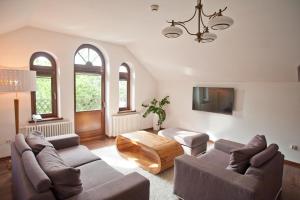 a living room with two couches and a table at Pensjonat Pod Jemiołą in Ciechocinek