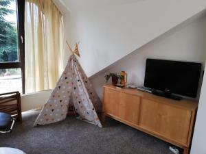 een woonkamer met een tv en een tent bij Bertha´s Home in Herne