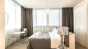 a bedroom with a bed and a table with a lamp at Perla Verde Hotel in Milano Marittima