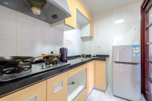 a kitchen with a stove and a refrigerator at Ben Shu Jia Apartment Pazhou Branch in Guangzhou