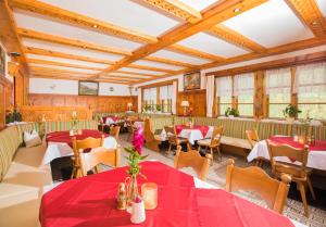 Sankt Sigmund im SellrainにあるAlpengasthof Praxmarの赤いテーブルと椅子、窓のあるレストラン