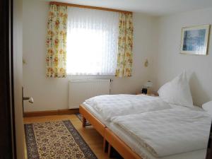 a bedroom with a white bed and a window at Ferienwohnung Haus Wagnershoehe in Gößweinstein +9 photos