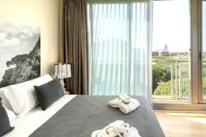 una camera d'albergo con un letto e asciugamani di Perla Verde Hotel a Milano Marittima