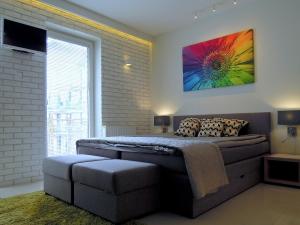 a bedroom with a bed and a colorful painting on the wall at 4UApart-Apartment studio Mohito in Świnoujście