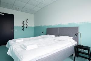 1 dormitorio con 1 cama grande con sábanas blancas en Neotel en Tallin