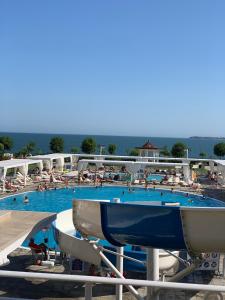 een groot zwembad met mensen in het water bij Private Apartment 49 in Prestige Fort Beach Hotel in Sveti Vlas