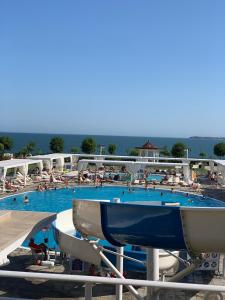a large swimming pool with people in the water at Private Apartment 49 in Prestige Fort Beach Hotel in Sveti Vlas
