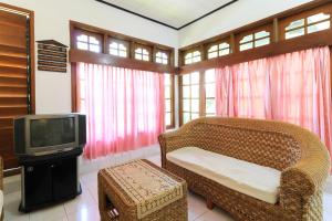 a living room with a couch and a tv at Sari Bali Resort in Kuta