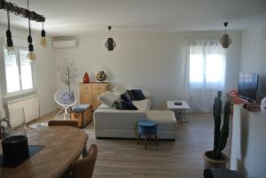 a living room with a couch and a table at Le Temps Retrouvé in Saint-Martin-de-Valgalgues